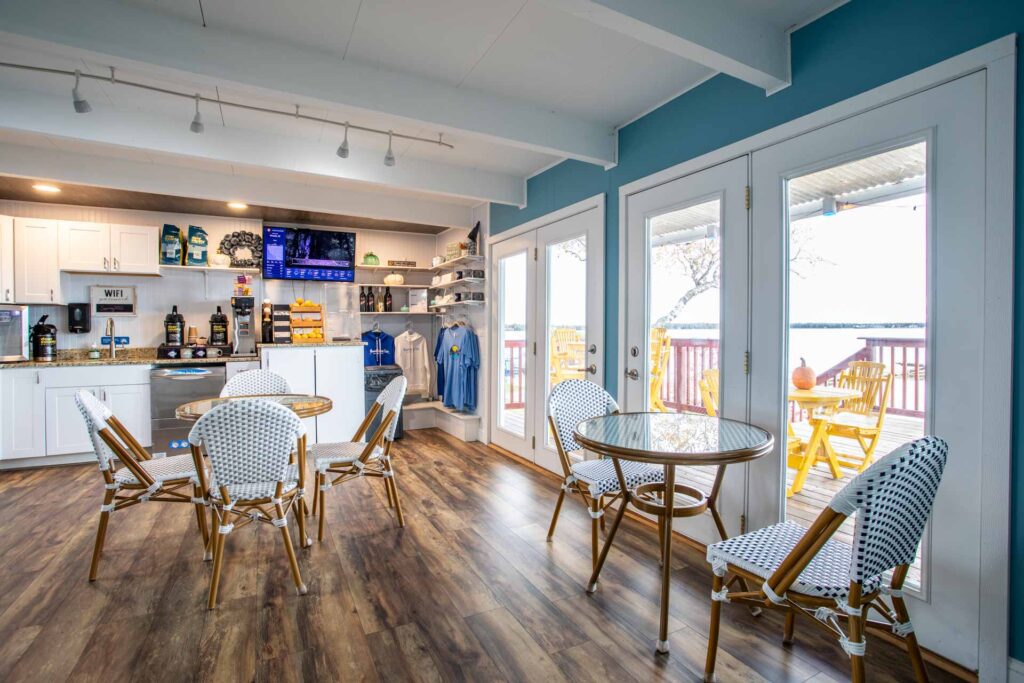 A second view of the lobby that shows the large doors to the patio, the breakfast and merchandise areas, and seating