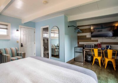 A view of the bathroom, TV, sitting area and appliances in Room 112